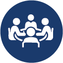 image appears to be an icon representing a group of people at a meeting or a round table discussion